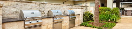 two stainless steel washers and dryers in a stone wall in front of a house