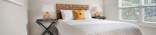 a bedroom with white walls and a yellow and white rug