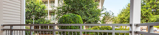 a white table and chairs sit on a balcony in front of an apartment building