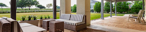 a covered patio with wicker furniture