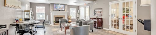 a living room with couches and chairs and a table and a fireplace