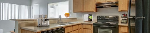 A kitchen with wooden cabinets and black appliances.