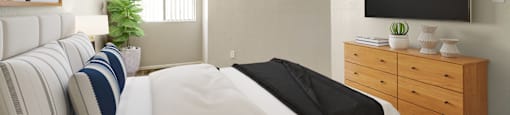 A bedroom with a large bed and a flat screen TV mounted on the wall.