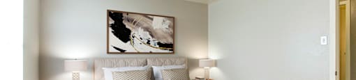 A bedroom with a large bed and a painting on the wall.