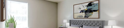 A bedroom with a large bed, a nightstand with a lamp, and a painting on the wall.
