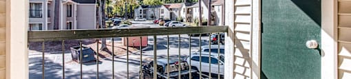a view of the street from a balcony with a gate