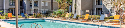 our apartments have a swimming pool with chairs and umbrellas