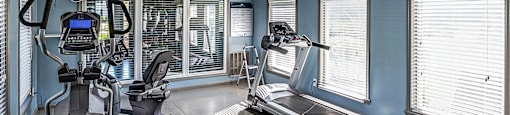 a home gym with a treadmill and a patient bed