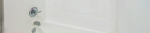 a white bathroom with a tub and a sink