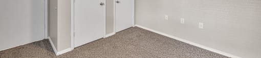 an empty bedroom with a ceiling fan and closet