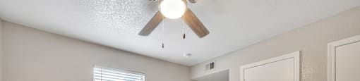 an empty bedroom with a ceiling fan and a door to a closet