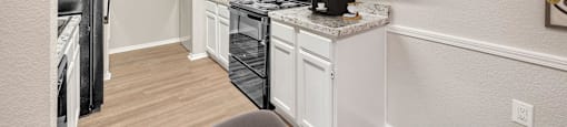 a kitchen with white cabinets and a black refrigerator
