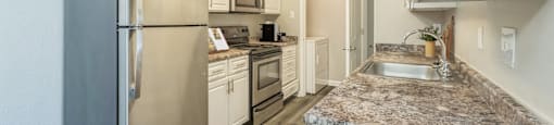 a kitchen with granite counter tops and stainless steel appliances