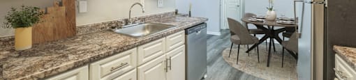 a kitchen and dining room with white cabinets and a stainless steel refrigerator