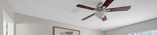 a bedroom with a bed and a ceiling fan