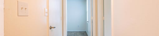 an empty hallway with wood floors and a white door