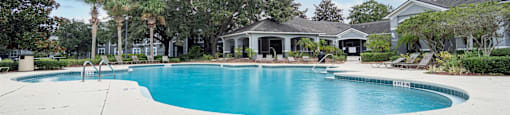 a large swimming pool with a house in the background