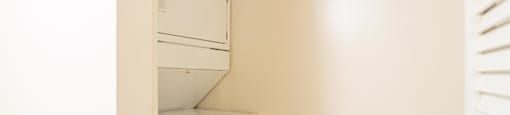 an empty laundry room with a washer and dryer in it