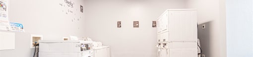 an empty laundry room with washer and dryer and white appliances
