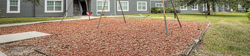 a swing set in front of an apartment building