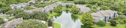 an aerial view of a neighborhood with a lake surrounded by houses