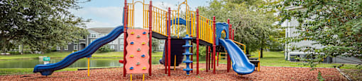 a playground with a swing set and slides in a park