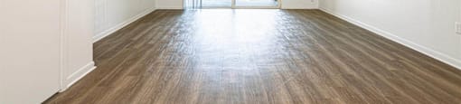 an empty living room with wood flooring and a door to a patio