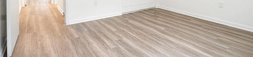 an empty living room with white walls and wood floors