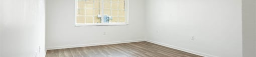 an empty room with white walls and a window