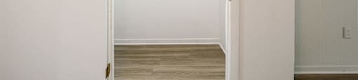 an empty room with a door open to a closet