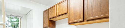 a small kitchen with wooden cabinets and a white dishwasher