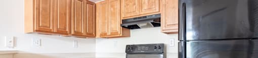 a kitchen with black appliances and wooden cabinets