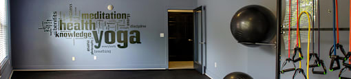 A yoga studio with a wall of words including "meditation", "health", "knowledge", and "yoga".
