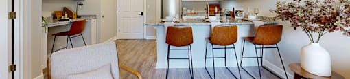 A kitchen with a bar area and chairs.