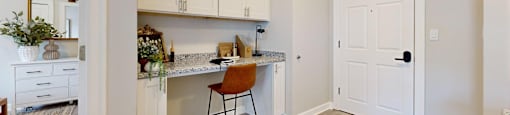 A kitchen with a white door and a brown chair.