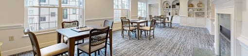 A large dining room with a fireplace and a long table.