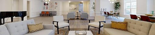A living room with a piano and a white couch.