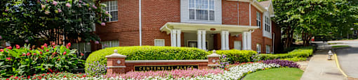 A brick house with a flower bed in front of it.