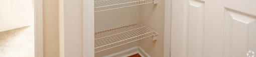 Empty white shelves in a pantry.