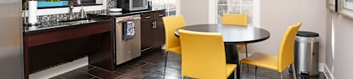 A kitchen with a table and chairs.