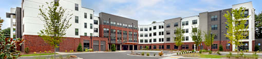 a view of the exterior of an apartment complex with sidewalks and grass