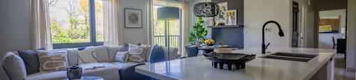 A modern kitchen and living room with a large island and a dining table.