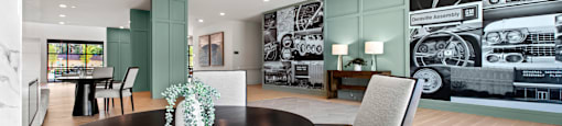a dining room with a table and chairs in front of a wall mural of cars