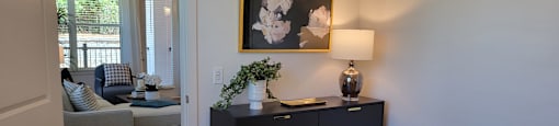 A bedroom with a black dresser and a painting on the wall.