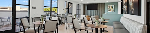 a dining room with tables and chairs and a balcony