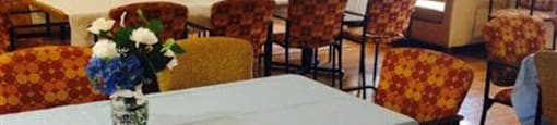 A dining room with a table set for a meal.