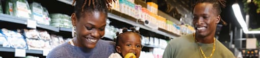 A woman and a man are shopping with a child in a grocery store.