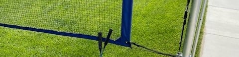 a tennis racket and two tennis balls on the grass next to a fenceat Westbury Apartments, Rancho Cucamonga, 91739