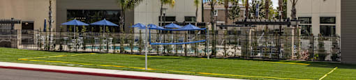 a building with umbrellas and palm trees in front of itat Westbury Apartments, Rancho Cucamonga, CA, 91739