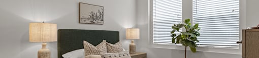 an empty bedroom with a bed and two windowsat Westbury Apartments, Rancho Cucamonga, CA, 91739